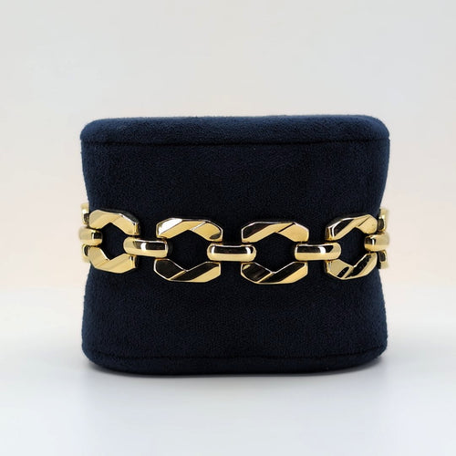 14K Italian geometric gold bracelet with articulated links displayed on a black velvet jewelry stand.
