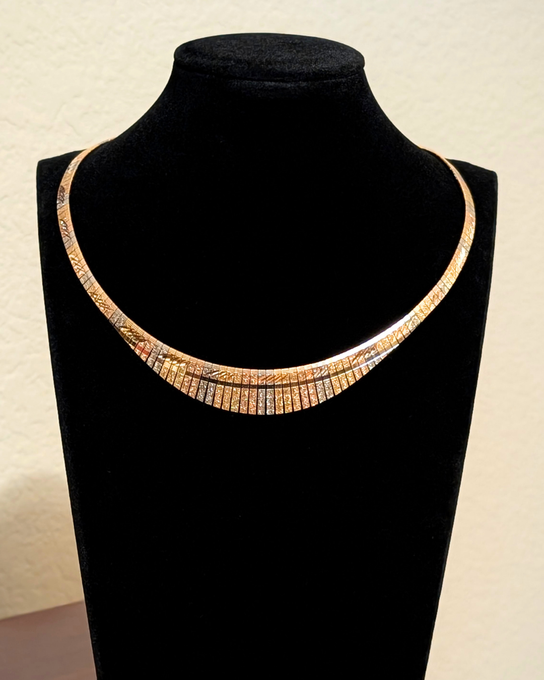 18K tri-tone gold Cleopatra collar necklace on black bust, etched vintage statement gold collar
Image 2 (Angle)
side view of 18K tri-tone gold Cleopatra collar necklace showing curved segmented design
Image 3 (Close detail)
close-up of etched tri-tone gold segments on 18K Cleopatra collar necklace
Image 4 (Second angle)
18K tri-tone gold collar necklace with reflective etched finish and structured silhouette