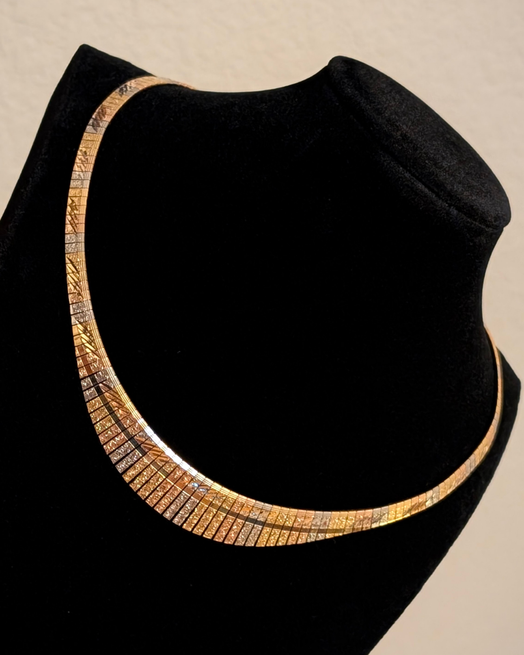 18K tri-tone gold Cleopatra collar necklace on black bust, etched vintage statement gold collar
Image 2 (Angle)
side view of 18K tri-tone gold Cleopatra collar necklace showing curved segmented design
Image 3 (Close detail)
close-up of etched tri-tone gold segments on 18K Cleopatra collar necklace
Image 4 (Second angle)
18K tri-tone gold collar necklace with reflective etched finish and structured silhouette