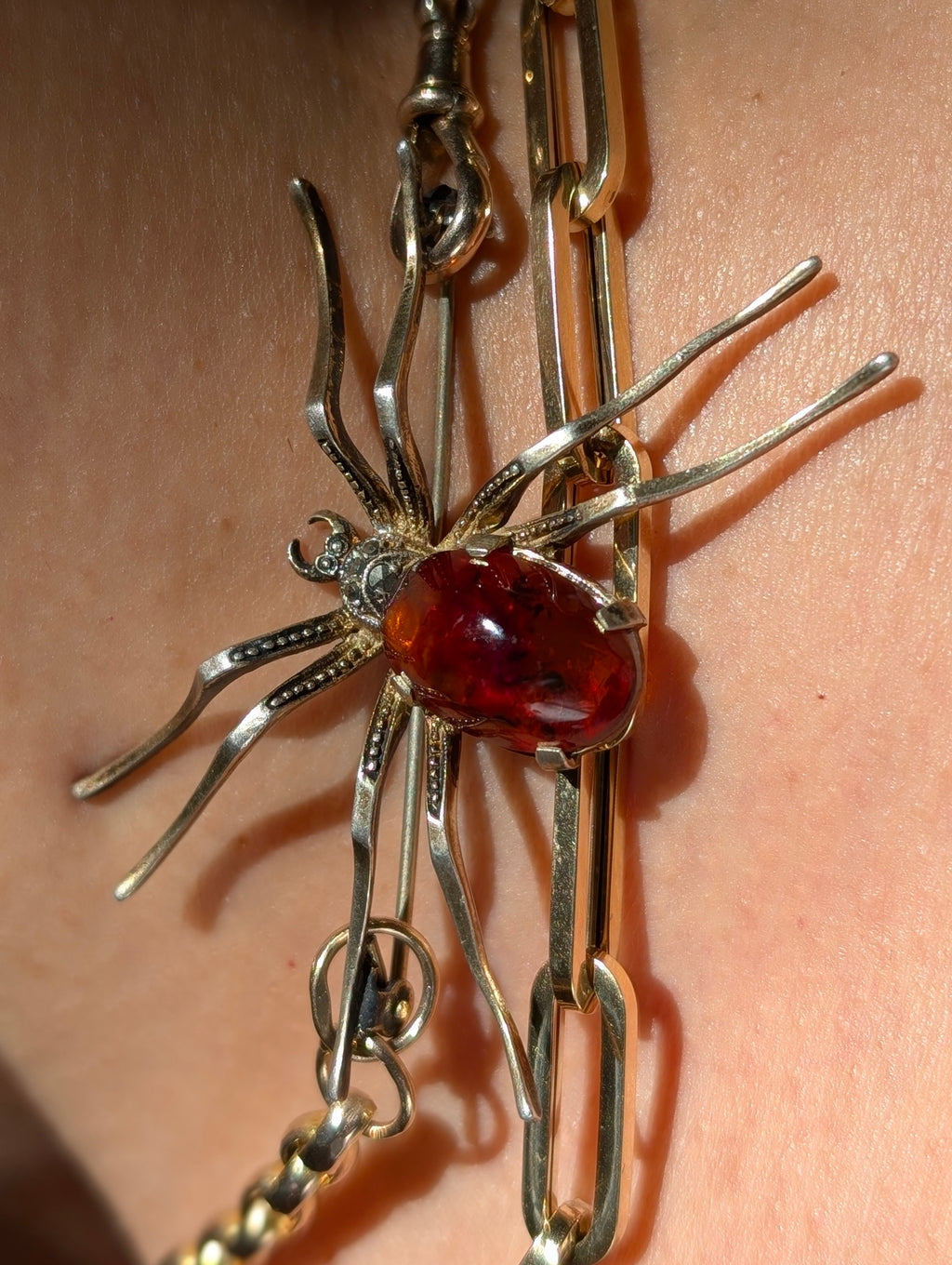 Sterling Silver Spider brooch with a natural amber cabochon  on a chain.