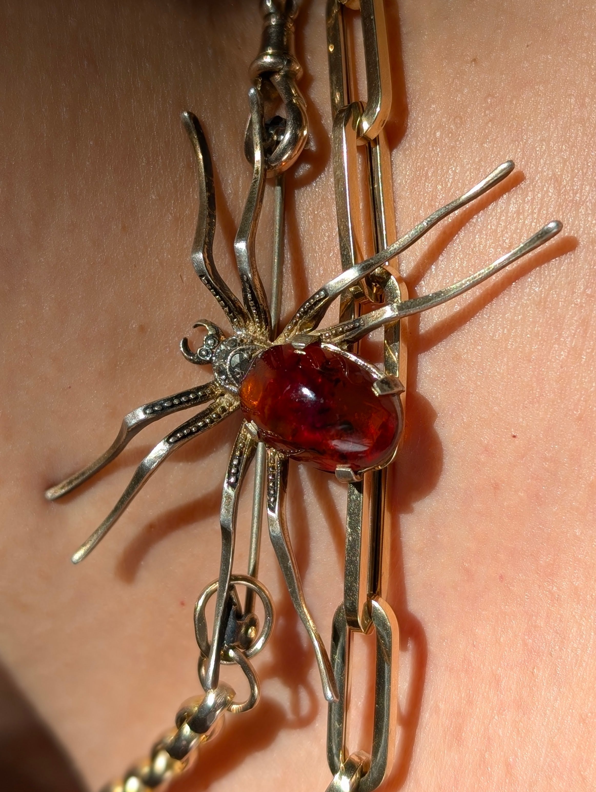 Sterling Silver Spider brooch with a natural amber cabochon  on a chain.