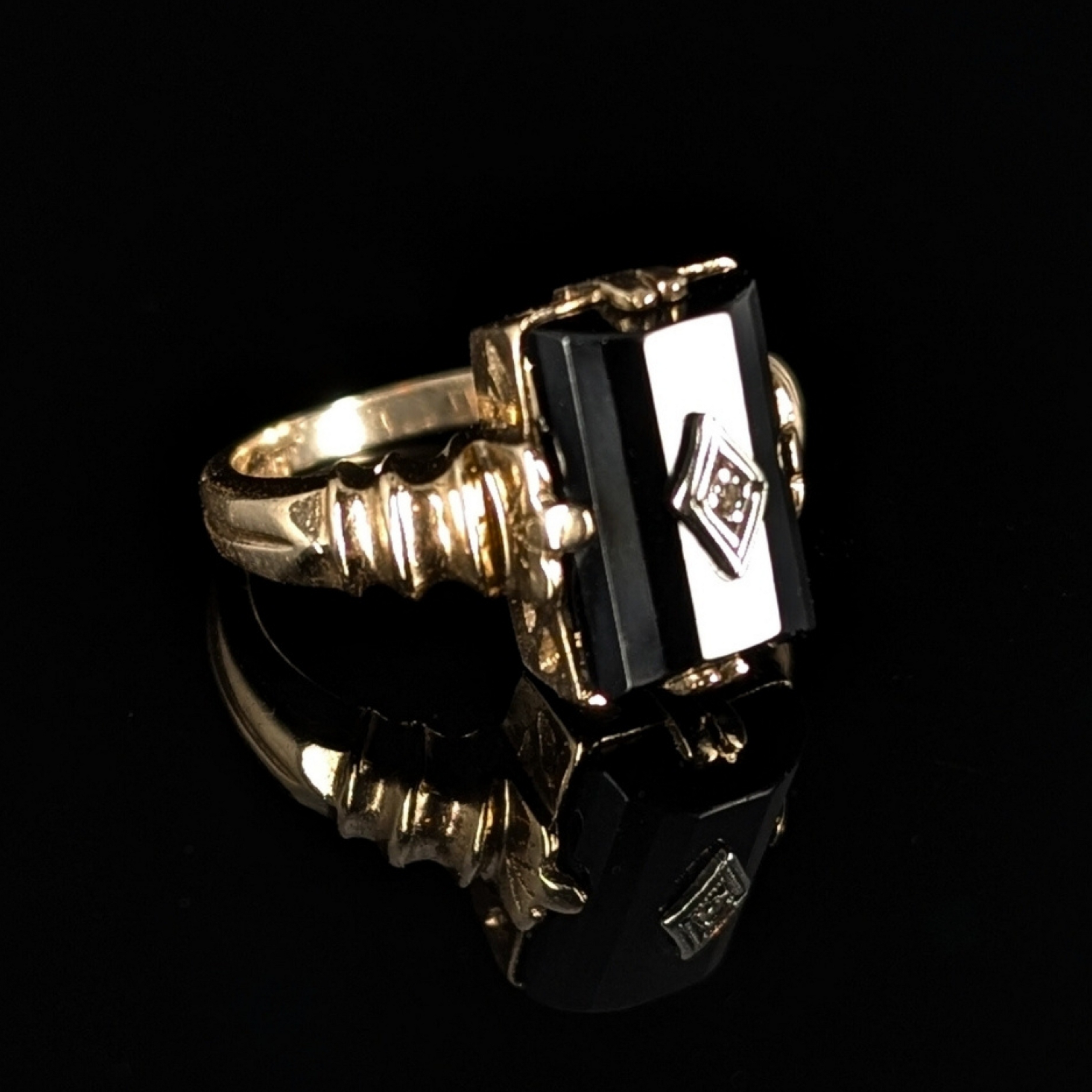 Gold ring with a black gemstone on a black background